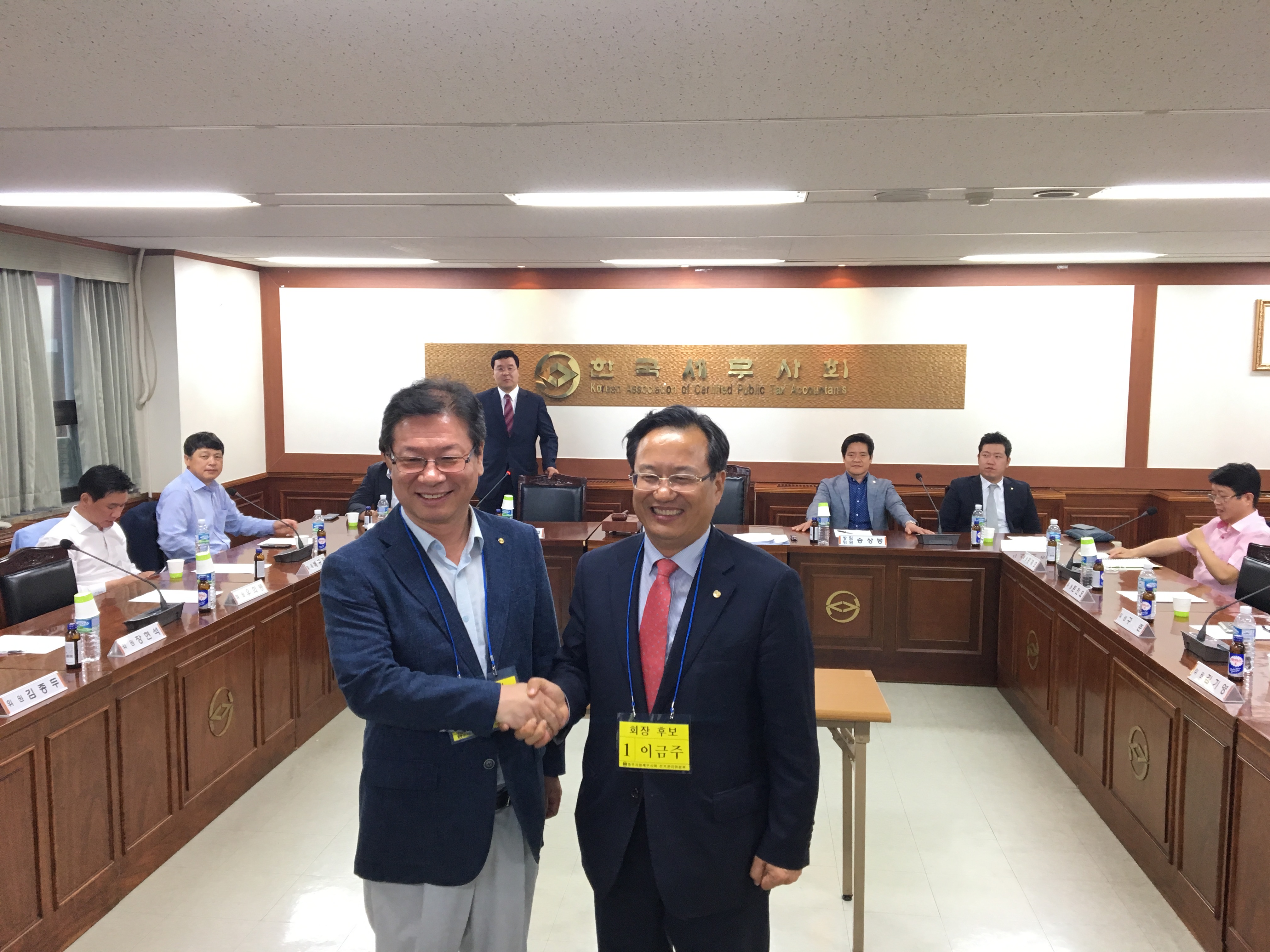 이금주 후보와 최훈 후보가 악수를 나누고 있다.