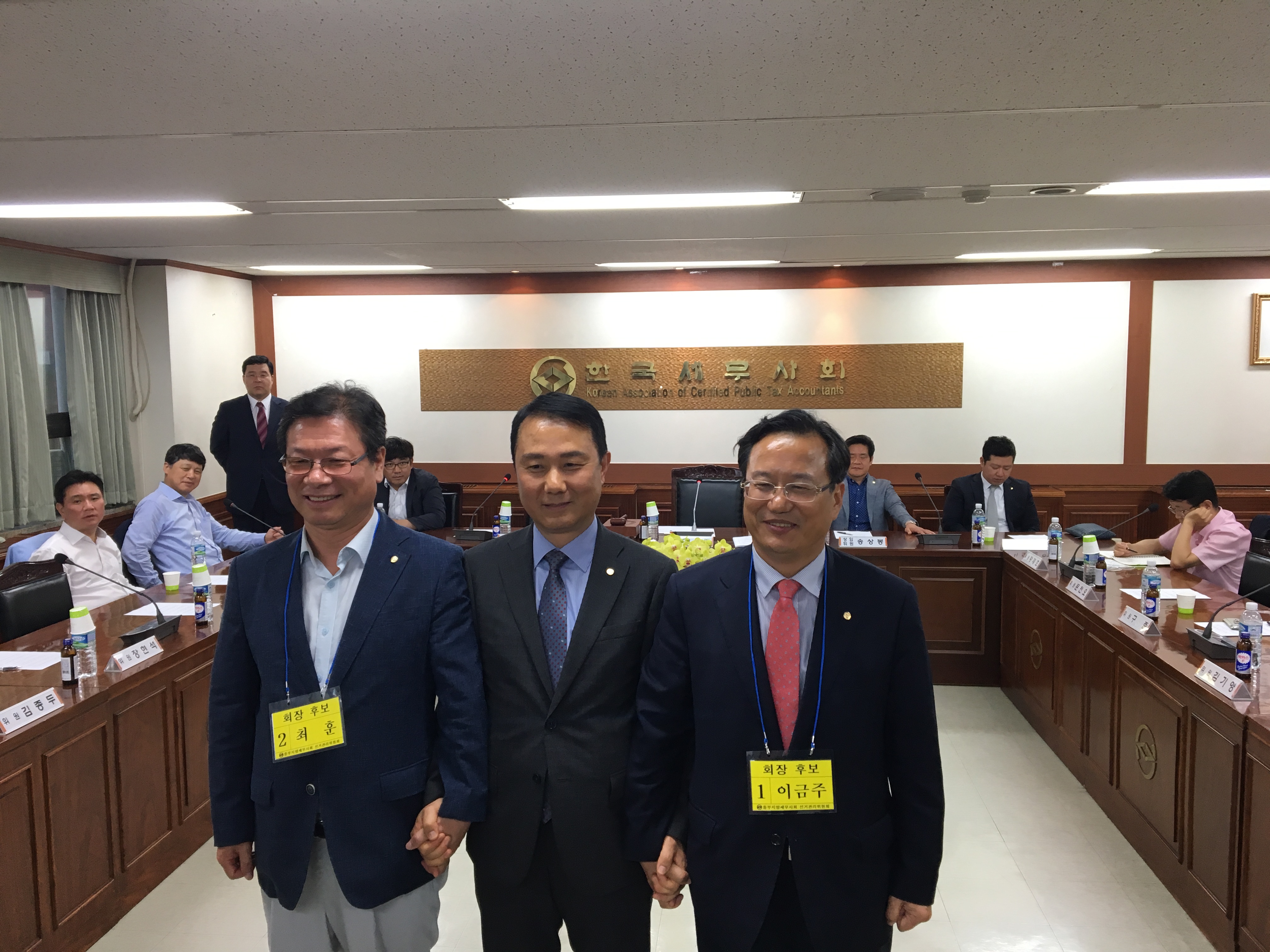 김주택<가운데> 선거관리위원장이 두 회장후보의 손을 맞잡고 공정선거를 다짐하고 있다.